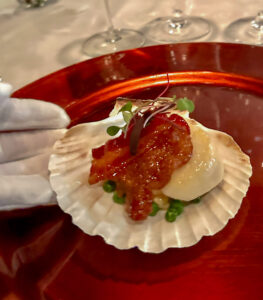 scallop and bacon served on a red plate