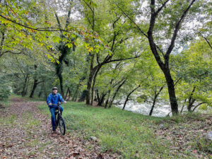 man riding a bike along a riverside