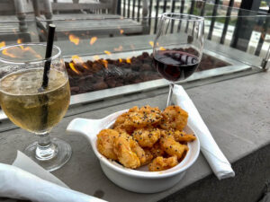 Cocktail, wine and shrimp appetizer next to a rooftop firepit overlooking Elkhart, Indiana