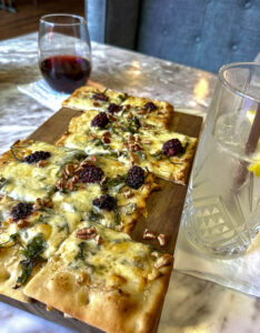 blackberry flatbread with cocktail and glass of wine